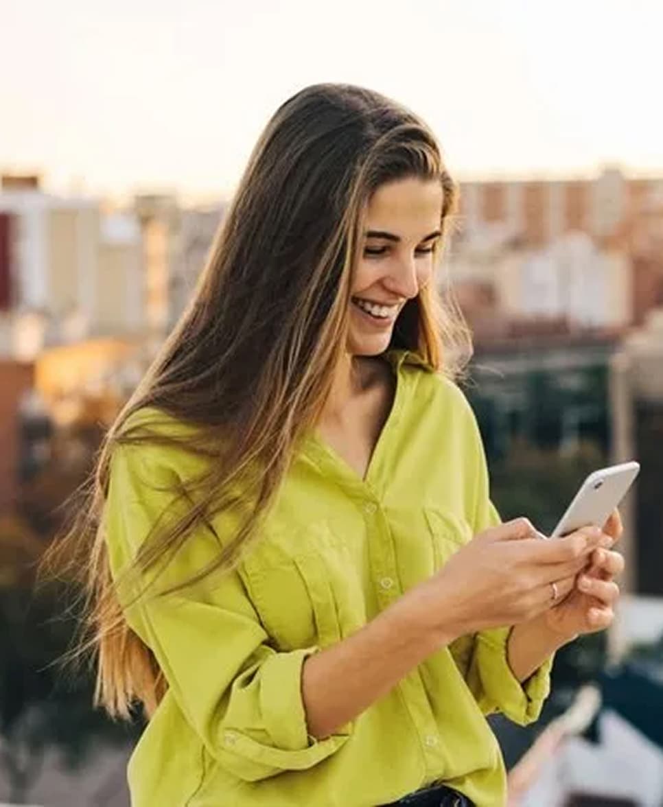 Woman smiling using device.